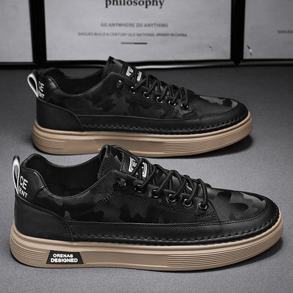 Schwarze Camouflage-Sneaker mit brauner Sohle, modisches Design, seitlich beschriftet, auf grauem Hintergrund, ideal für urbane Streetwear-Looks.