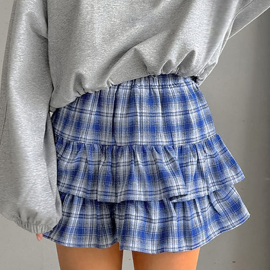 Grauer Pullover und blauer karierter Rüschenrock, modisches Outfit, Damenmode, lässiger Stil, Herbstkleidung, trendige Bekleidung.