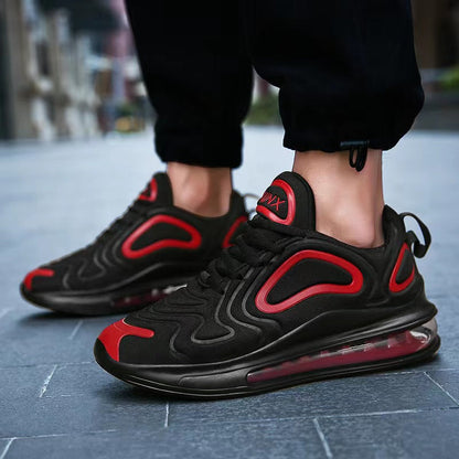 Schwarze und rote Sneaker mit Luftpolstersohle auf grauem Boden. Moderne Sportschuhe, ideal für Laufen und Freizeit. Trendige Herrenmode.
