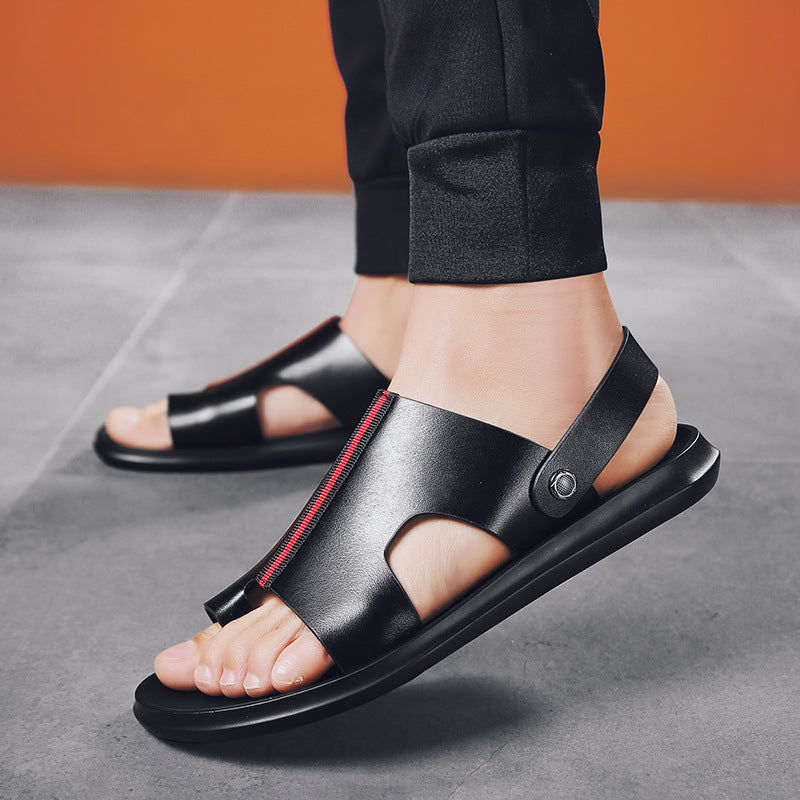 Schwarze Ledersandalen für Herren mit rotem Reißverschluss, getragen auf grauem Boden. Modische Sommerschuhe, bequem und stilvoll.