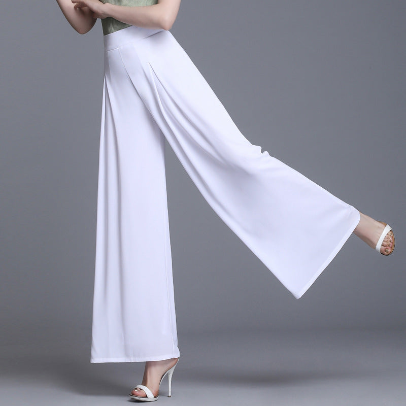 Frau in eleganter, weißer, weiter Hose und hohen Absätzen, grauer Hintergrund. Modetrend, Damenbekleidung, stilvolle Sommerhose.