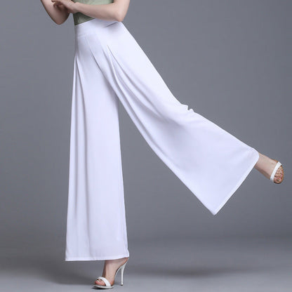 Frau in eleganter, weißer, weiter Hose und hohen Absätzen, grauer Hintergrund. Modetrend, Damenbekleidung, stilvolle Sommerhose.