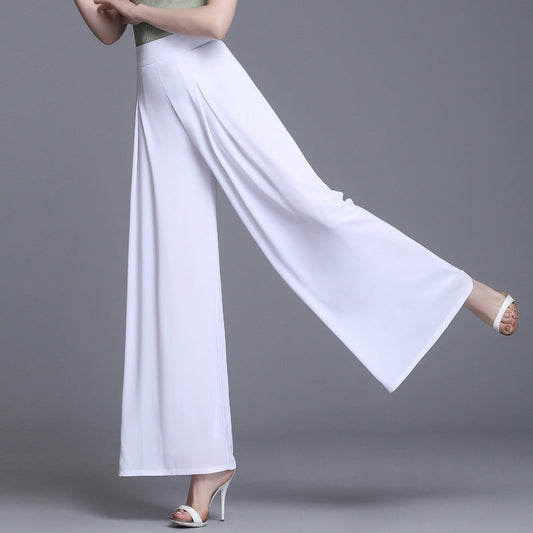 Frau in eleganter, weißer, weiter Hose und hohen Absätzen, grauer Hintergrund. Modetrend, Damenbekleidung, stilvolle Sommerhose.