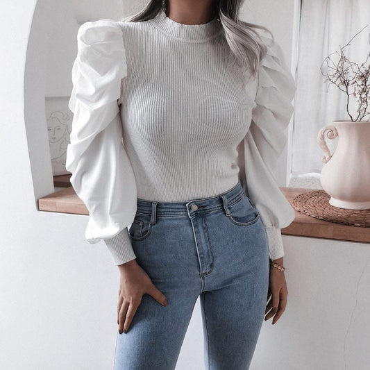 Frau in weißem Pullover mit Puffärmeln und blauer Jeans, modisches Outfit, moderne Damenmode, stilvolle Kleidung, elegantes Design.