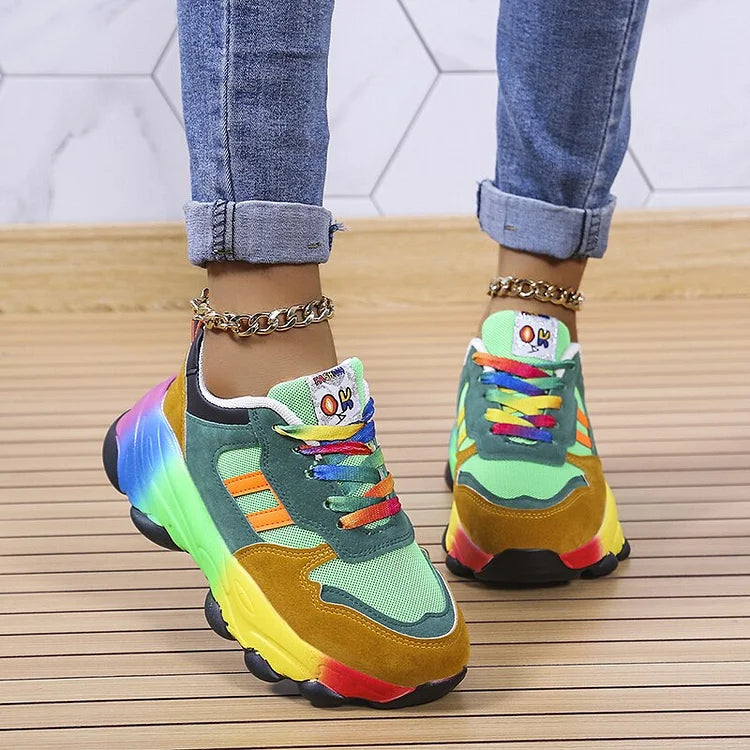 Bunte Sneaker mit Regenbogenfarben, getragen von Person in Jeans. Modische Turnschuhe, auffälliges Design, trendige Schuhe, Holzboden.