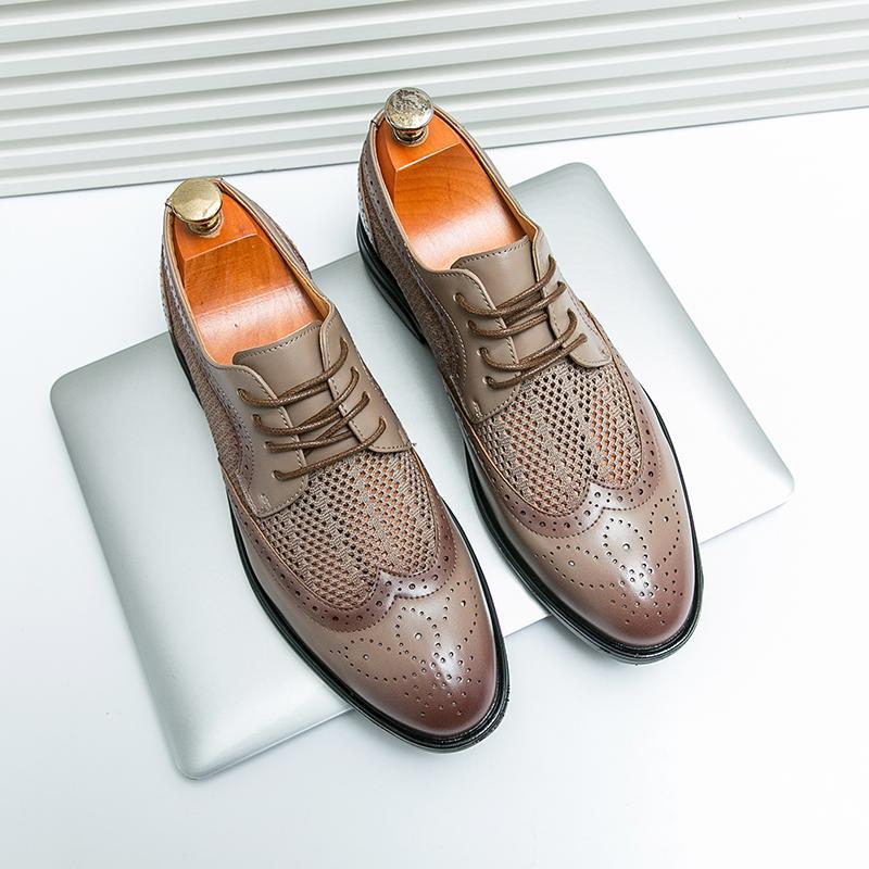 Braune Herren-Brogues aus Leder mit Lochmuster, auf einem silbernen Laptop platziert. Elegante Business-Schuhe, ideal für formelle Anlässe.