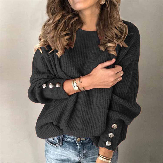 Dame in grauem Strickpullover mit Knöpfen an den Ärmeln, trägt Jeans und Schmuck. Modetrend, Herbstmode, lässiger Look.