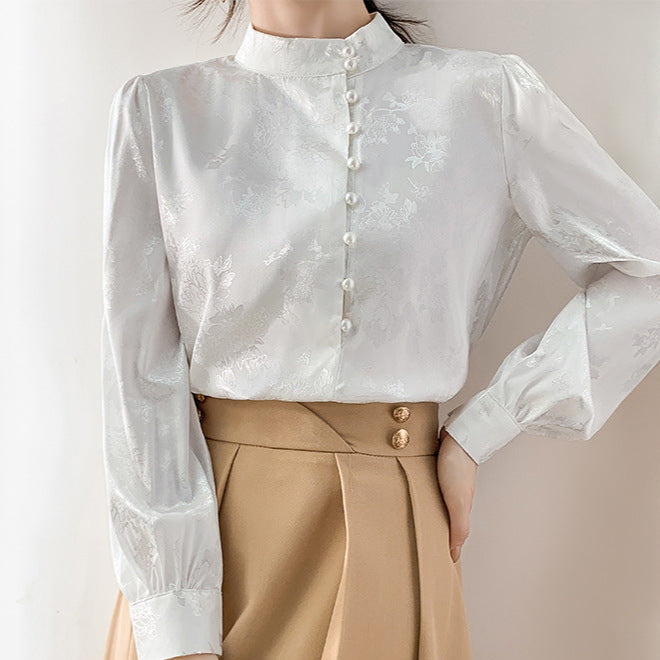 Elegante weiße Bluse mit Stehkragen und Knopfleiste, kombiniert mit beiger Hose. Damenmode, stilvolle Büro-Outfits, klassische Eleganz.