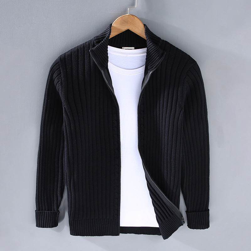 Schwarze Strickjacke mit Reißverschluss auf Bügel, kombiniert mit weißem T-Shirt. Modische Herrenbekleidung, ideal für Herbst und Winter.