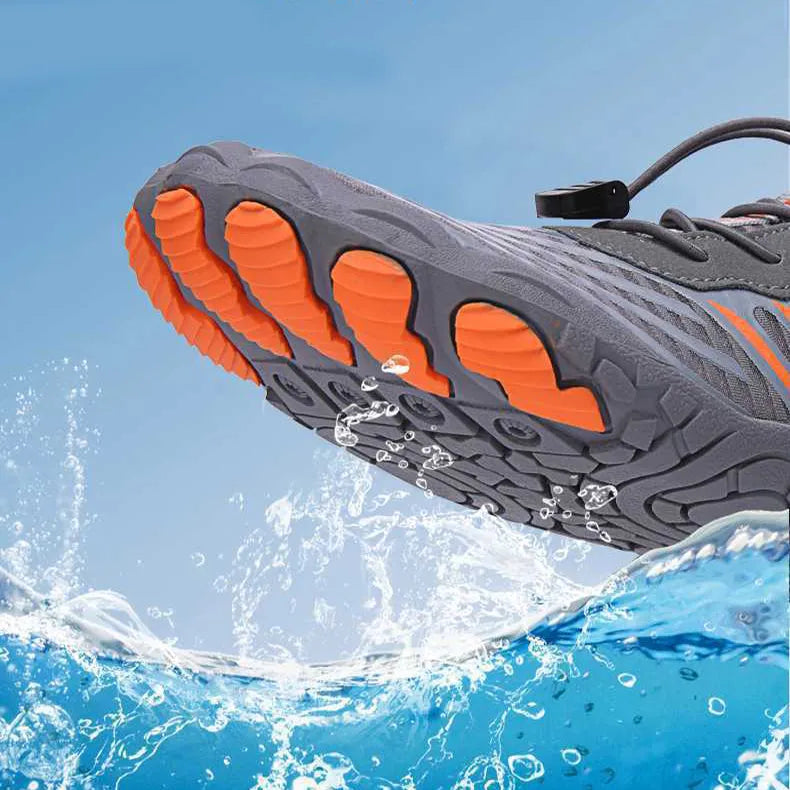 Grauer und orangefarbener Wasserschuh über spritzendem Wasser, rutschfeste Sohle, ideal für Outdoor-Aktivitäten, Schwimmen, Wandern.