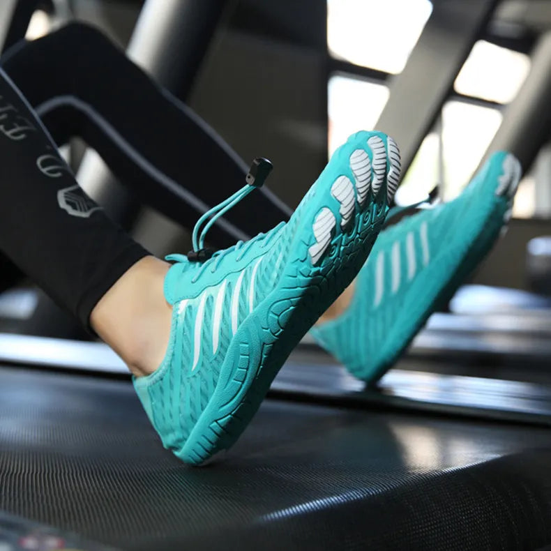 Türkise Barfußschuhe auf Laufband, minimalistisches Design, flexible Sohle, ideal für Fitness und Laufen, fördern natürliche Fußbewegung.
