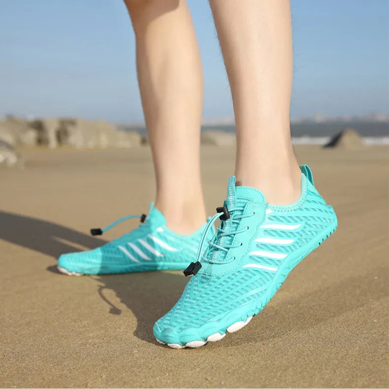 Türkise Barfußschuhe am Strand, ideal für Sommer und Outdoor-Aktivitäten. Leichte, atmungsaktive Schuhe für Herren und Damen.