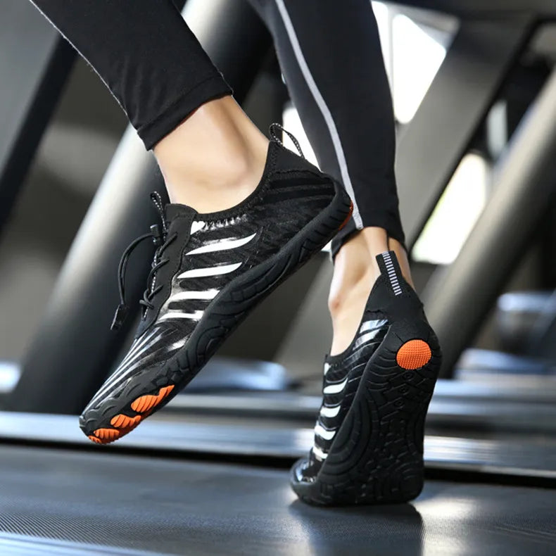 Schwarze Barfußschuhe auf Laufband, minimalistisches Design, flexible Sohle, ideal für Fitness und Laufen, sportliche Damenbeine in Bewegung.