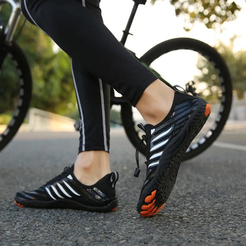 Fahrradfahrer mit schwarzen, rutschfesten Sportschuhen auf Asphaltstraße. Outdoor-Aktivität, Fitness, Radfahren, Sportbekleidung.