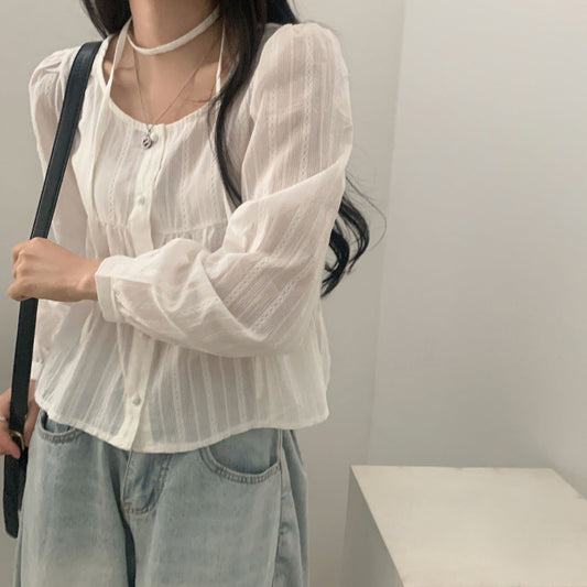 Frau in weißer Bluse und blauer Jeans, trägt schwarze Umhängetasche. Modetrend, lässiger Stil, elegante Damenbekleidung, Alltagsoutfit.