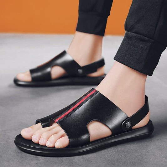 Schwarze Ledersandalen für Herren mit offenem Zehenbereich und rotem Streifen, getragen mit schwarzer Hose. Ideal für Sommermode und Freizeitkleidung.