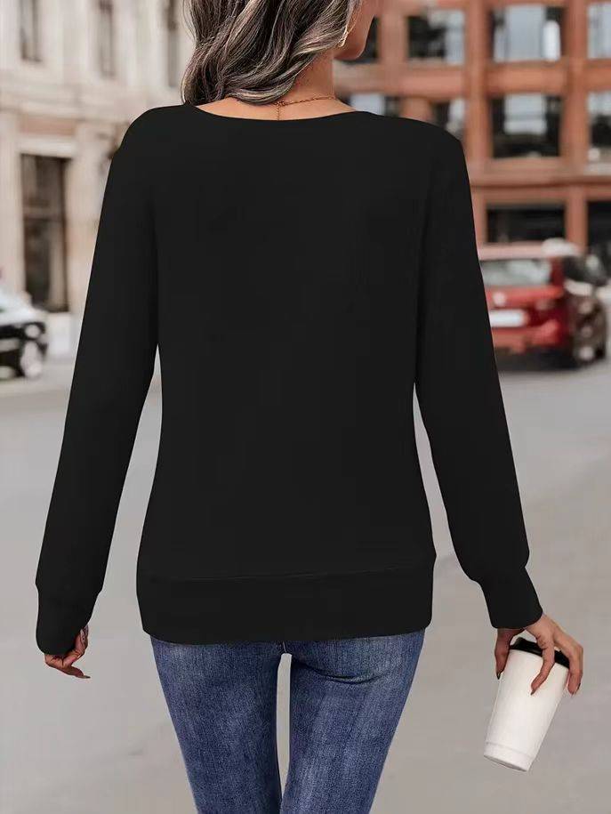 Frau in schwarzem Pullover und blauer Jeans hält Kaffeebecher, geht auf städtischer Straße. Mode, Freizeitkleidung, Stadtleben.
