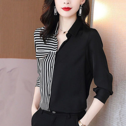 Elegante Frau in schwarz-weiß gestreifter Bluse, kombiniert mit schwarzer Hose. Modische Büro-Outfit, ideal für Business- und Casual-Anlässe.