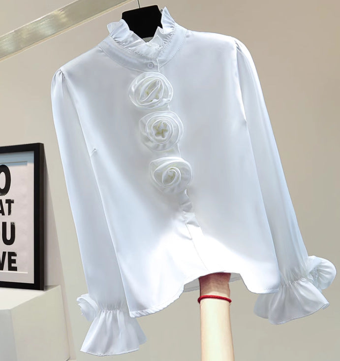 Weiße Bluse mit Rüschen und Rosenapplikationen, elegantes Design, langärmlig, perfekt für formelle Anlässe, Damenmode, stilvoll und modern.