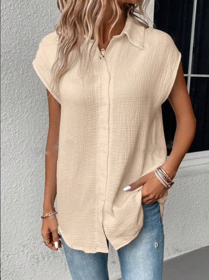 Frau in beiger, ärmelloser Bluse aus Baumwolle, kombiniert mit blauen Jeans. Modetrend, lässiger Sommerlook, Damenbekleidung.