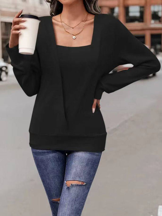 Frau in schwarzem Pullover und zerrissenen Jeans hält Kaffeebecher. Modetrend, lässiger Streetstyle, urbaner Hintergrund.