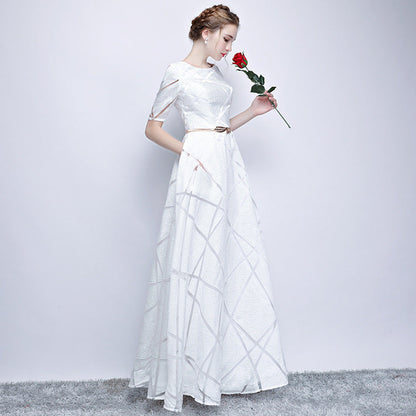 Frau in elegantem weißen Abendkleid mit Gürtel, hält rote Rose. Perfekt für Hochzeiten, formelle Anlässe. Eleganz, Mode, Abendgarderobe.