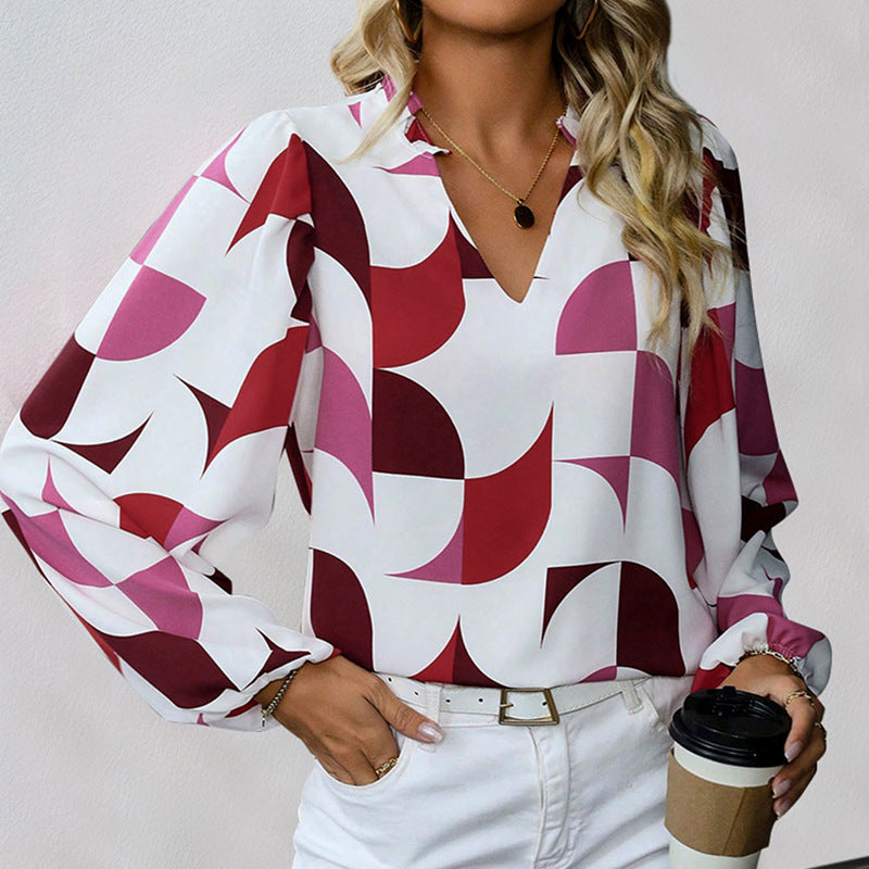 Frau in geometrisch gemusterter Bluse mit Rot- und Rosatönen, hält Kaffeebecher. Modetrend, Damenmode, stilvolle Bluse, Freizeitlook.