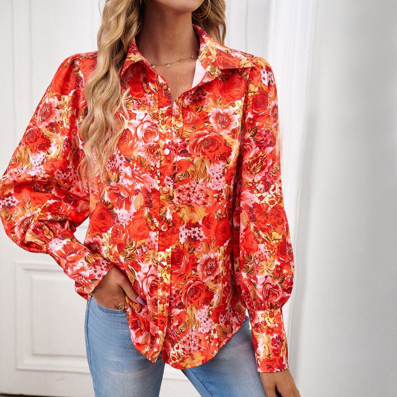 Frau trägt rote, geblümte Bluse mit langen Ärmeln und Jeans. Modetrend, Damenmode, florales Design, stilvolle Kleidung, Freizeitlook.