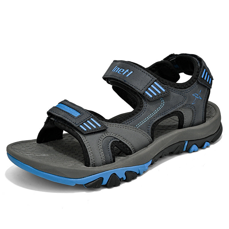 Graue und blaue Outdoor-Sandale mit Klettverschluss, rutschfester Sohle und robustem Design. Ideal für Wandern und Freizeitaktivitäten.
