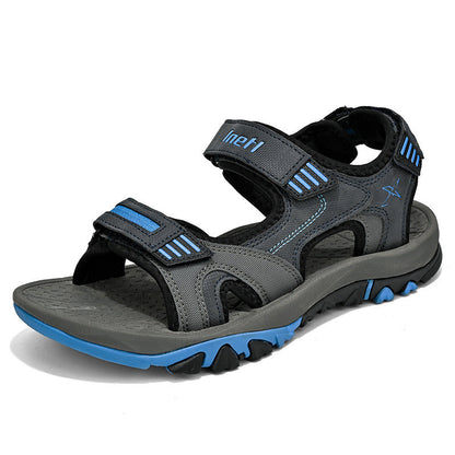 Graue und blaue Outdoor-Sandale mit Klettverschluss, rutschfester Sohle und robustem Design. Ideal für Wandern und Freizeitaktivitäten.