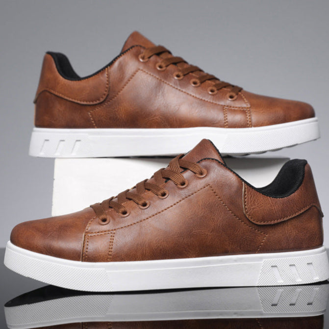 Braune Ledersneaker mit weißer Sohle, seitlich gestapelt. Modische Herrenschuhe, ideal für Freizeit und Alltag. Elegantes Design, bequemer Tragekomfort.