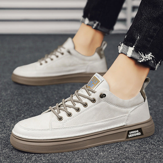 Weiße Sneaker mit brauner Sohle, getragen von Person in zerrissenen Jeans. Modische Freizeitschuhe, ideal für urbanen Streetstyle.