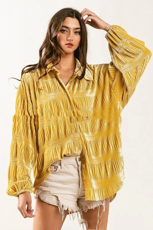 Gelbe, plissierte Bluse mit langen Ärmeln, getragen von Frau mit langen Haaren. Modetrend, lässiger Stil, Damenmode, Sommeroutfit.
