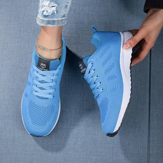 Blaue Sportschuhe auf Jeansstoff, moderne Sneaker mit weißer Sohle, Damenmode, Freizeitlook, bequeme Laufschuhe, trendige Fußbekleidung.