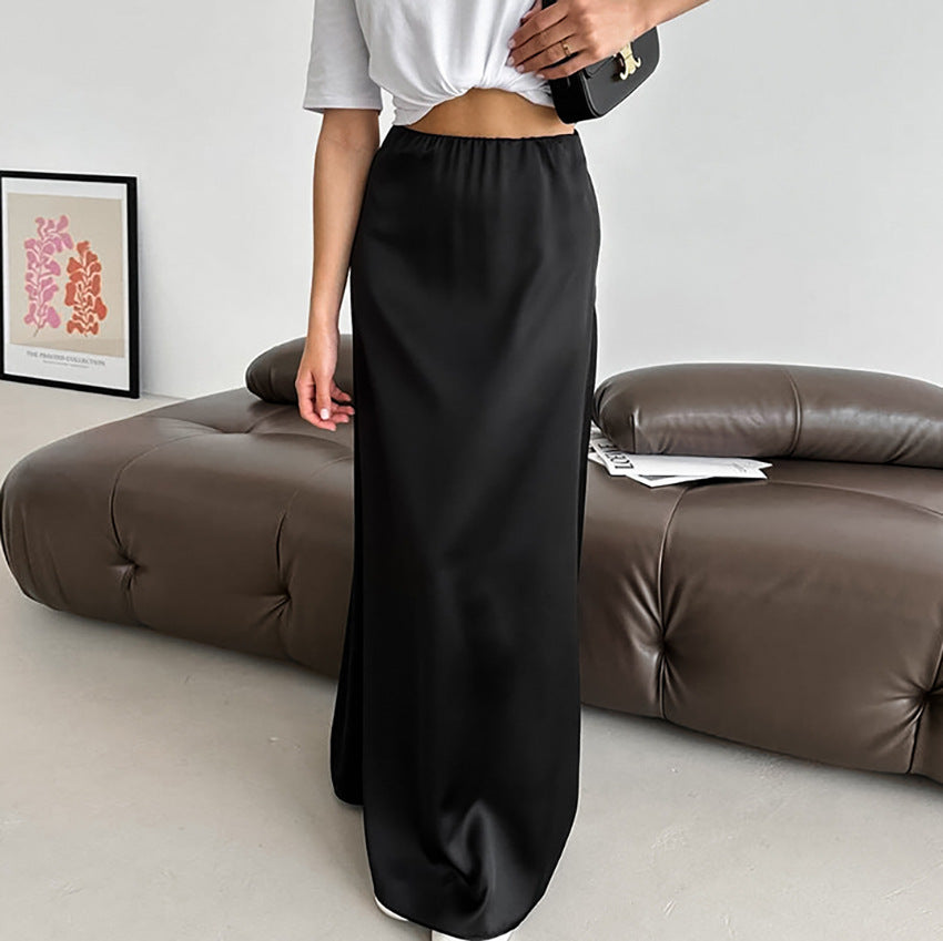 Frau in schwarzem Satinkleid steht vor braunem Ledersofa, modernes Interieur, minimalistische Kunst an der Wand, elegante Mode, stilvoller Look.