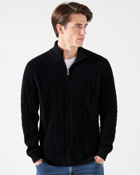 Mann im schwarzen Zopfmuster-Pullover mit Reißverschluss, weißem T-Shirt und blauer Jeans. Modischer Herrenstrickpullover, stilvoll und elegant.