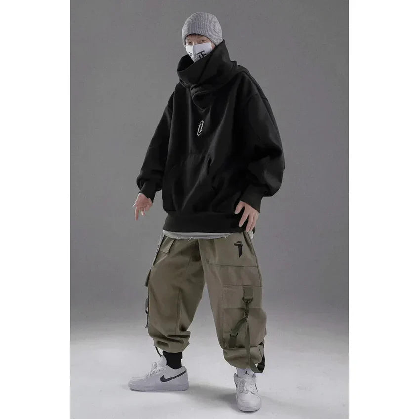 Grauer Hoodie, beiger Cargohose, weiße Sneaker, graue Mütze, Maske; urbaner Streetwear-Look, lässige Mode, trendige Herrenbekleidung.