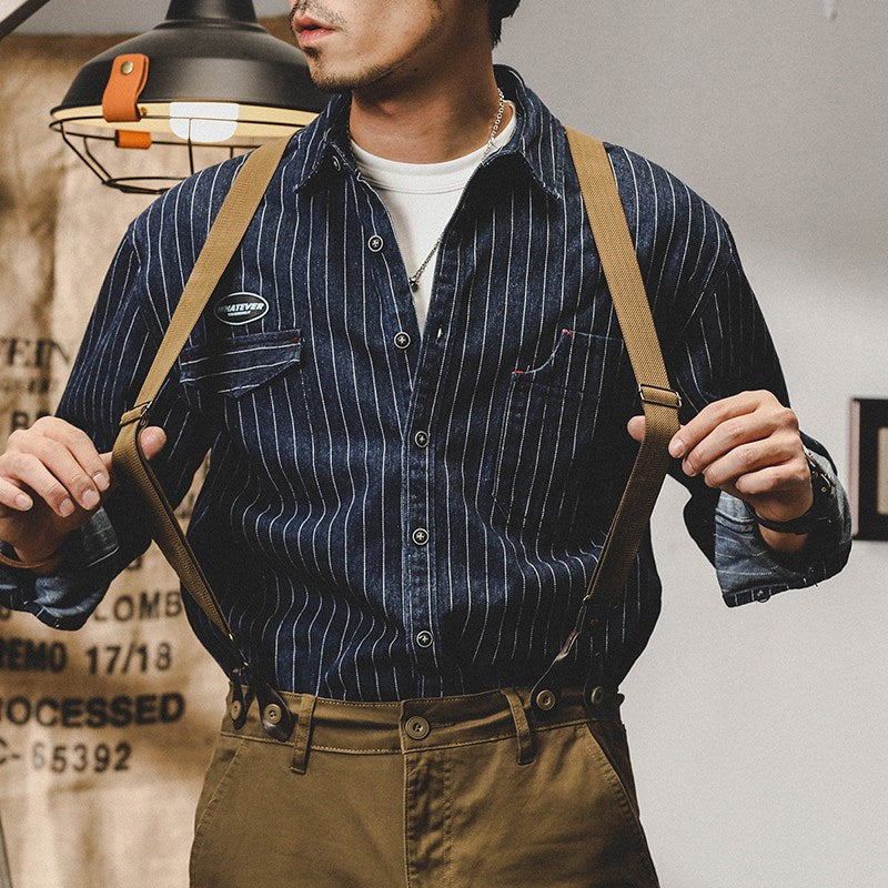Mann in gestreiftem Hemd und brauner Hose mit Hosenträgern, Vintage-Stil, modisch, lässig, Retro-Mode, Herrenbekleidung, urbaner Look.