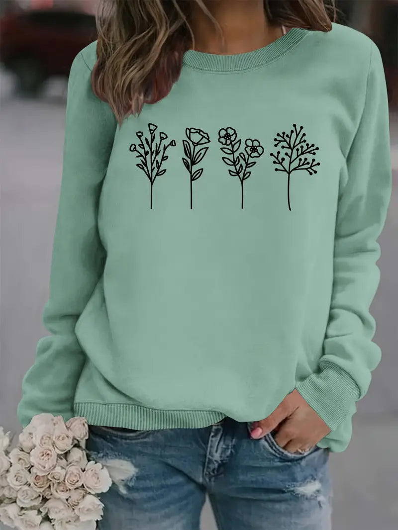 Frau in mintgrünem Pullover mit Blumenmuster, hält Rosenstrauß. Modetrend, lässiger Stil, Damenmode, florales Design, Jeans.