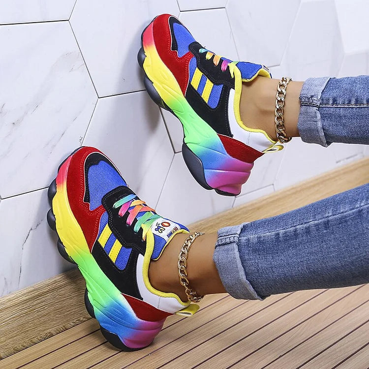 Bunte Sneaker mit Regenbogenfarben, getragen von Person in Jeans. Modische Sportschuhe, trendiges Design, auffällige Farben, lässiger Stil.