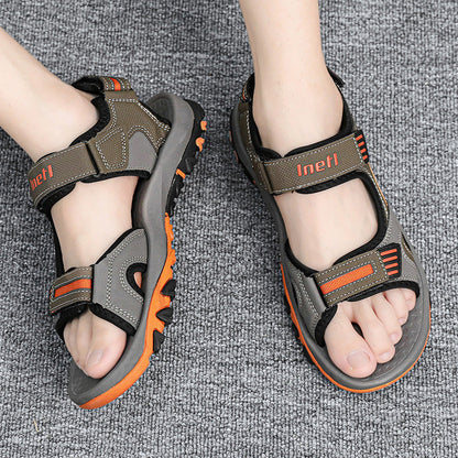 Herren-Trekkingsandalen auf grauem Teppich, robustes Design, verstellbare Riemen, rutschfeste Sohle, ideal für Outdoor-Aktivitäten.