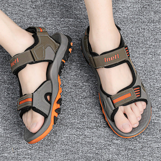 Herren-Trekkingsandalen auf grauem Teppich, robustes Design, verstellbare Riemen, rutschfeste Sohle, ideal für Outdoor-Aktivitäten.