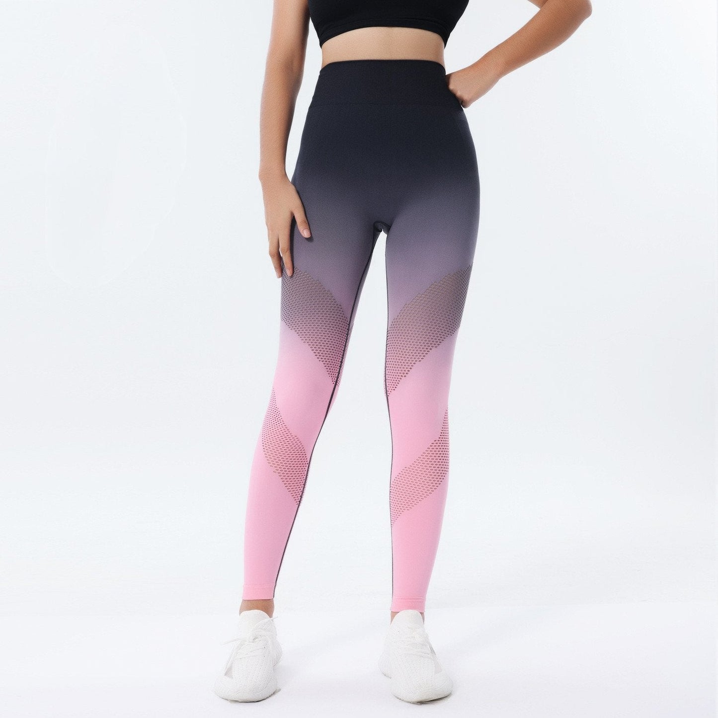 Frau in modischen, nahtlosen Sportleggings in Rosa und Schwarz, kombiniert mit einem schwarzen Sport-BH. Perfekt für Fitness und Yoga.