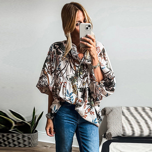 Frau in floralem Hemd und Jeans macht Selfie im modernen Wohnzimmer, Pflanzen im Hintergrund. Mode, Selfie, Freizeitkleidung, Innenraum.