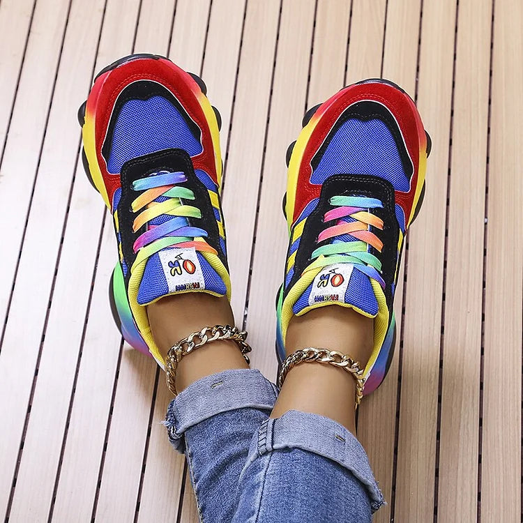 Bunte Sneaker mit Regenbogenfarben, getragen von Person in Jeans, auf Holzboden. Modische Turnschuhe, trendige Schuhe, farbenfrohes Design.