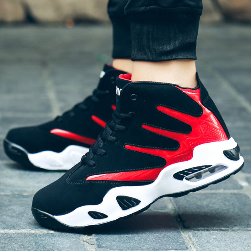 Schwarze und rote Sportschuhe mit weißer Sohle auf grauem Pflaster. Modische Sneaker, ideal für Laufen und Freizeit. Hochwertige Turnschuhe.