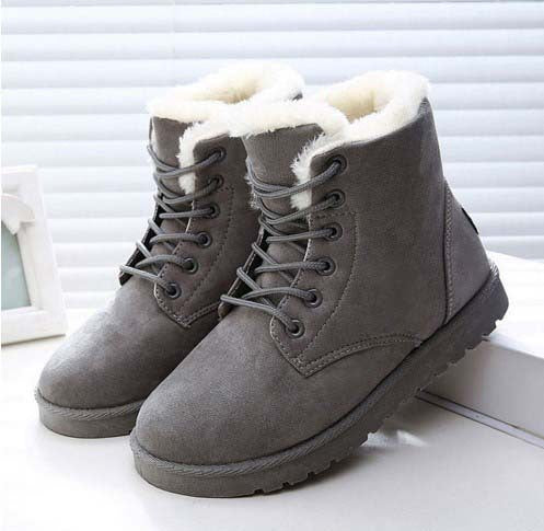 Graue Winterstiefel mit weißem Kunstfellfutter, robustem Design und Schnürung, ideal für kaltes Wetter. Perfekt für Damenmode und Outdoor-Aktivitäten.