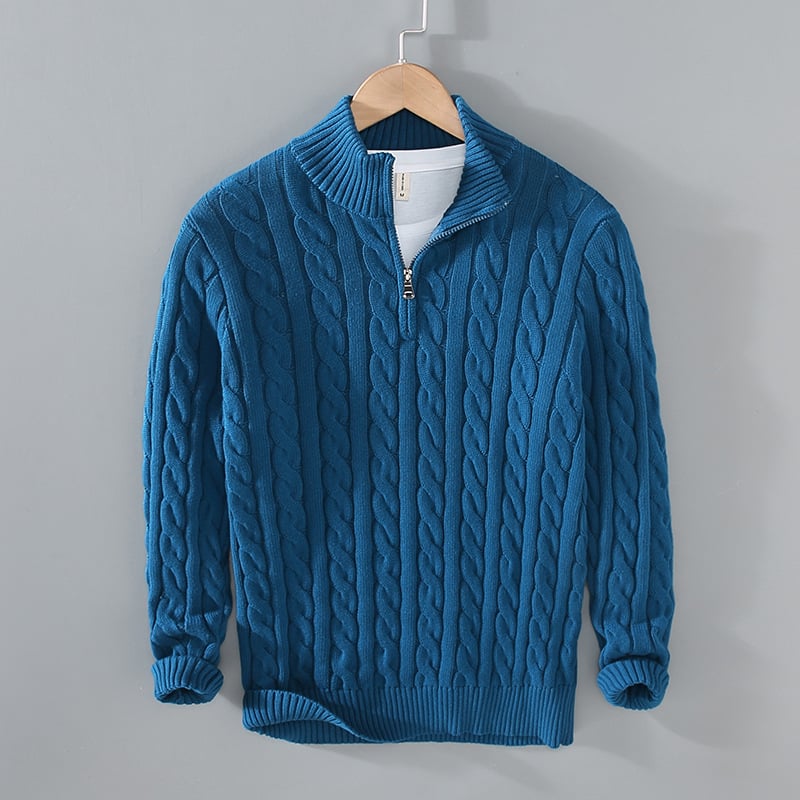 Blauer Strickpullover mit Zopfmuster, Reißverschluss und Stehkragen auf Holzkleiderbügel. Modischer Herrenpullover, warm und stilvoll.