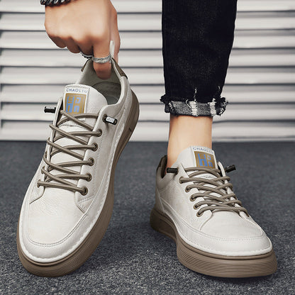 Moderne graue Herrensneaker mit brauner Sohle, getragen von Person mit schwarzer Jeans. Stilvolle Freizeitschuhe, ideal für urbanen Look.