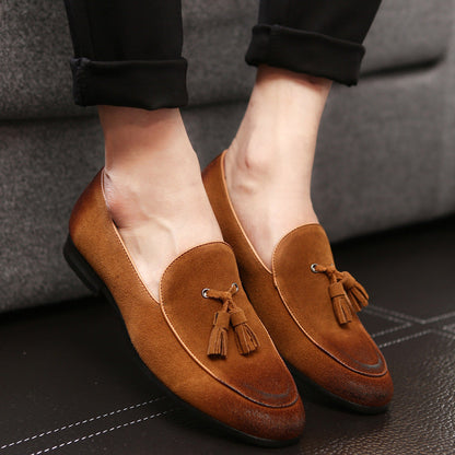 Braune Wildleder-Loafer mit Quasten, getragen von einer Person auf dunklem Boden. Elegante Herrenschuhe, modisch und bequem für den Alltag.